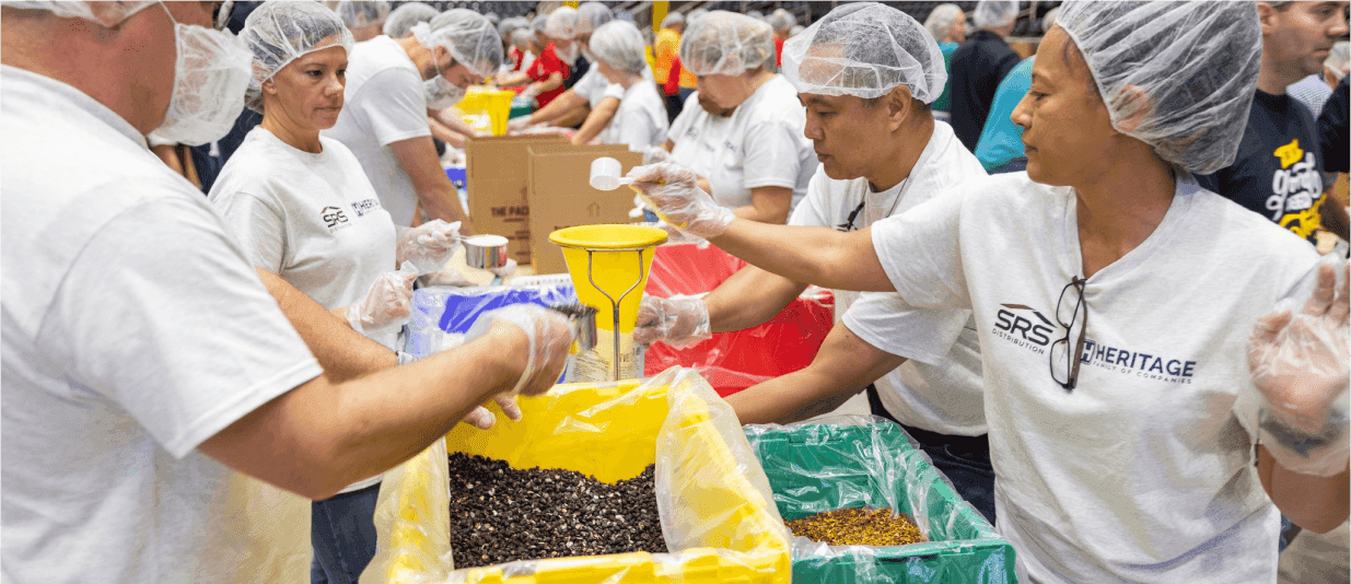 Volunteers putting together food packages at an event.